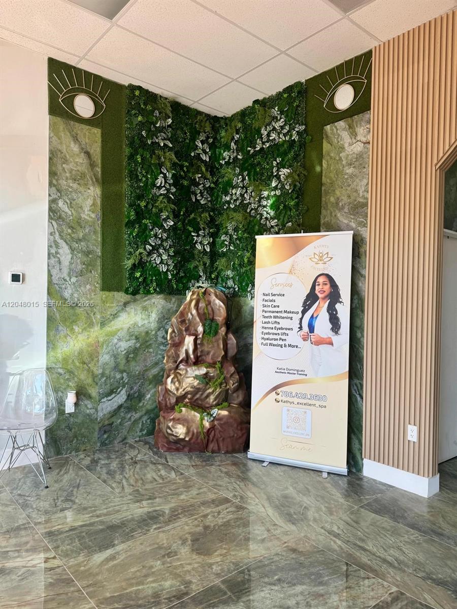 A spa reception area features a green wall, a rock fountain, and a service banner — 18710 SW 107 ave, Miami FL 33157, MIAMI, FL