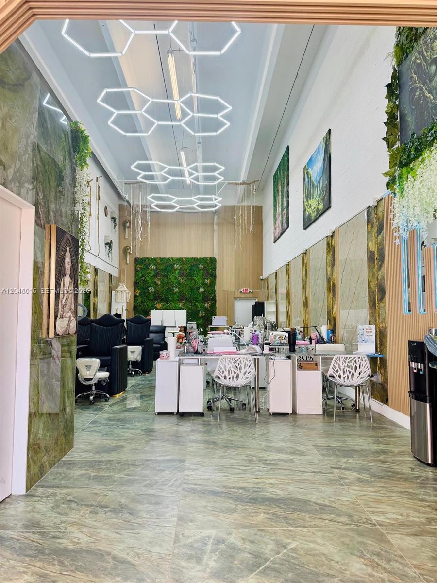 A modern nail salon features hexagonal ceiling lights, green marble flooring, and a living wall — 18710 SW 107 ave, Miami FL 33157, MIAMI, FL