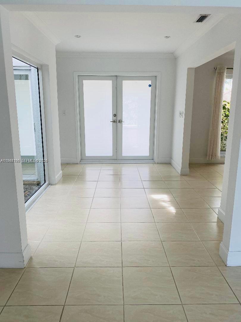 A single-story house with a stone facade, white trim, and lush tropical landscaping — 1460 Tagus Ave, Coral Gables FL 33156, CORAL GABLES, FL