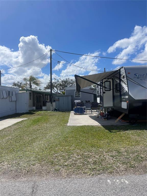 A travel trailer with an extended awning sits on a concrete pad next to mobile homes — 138 PENNSYLVANIA STREET, PALMETTO, FL