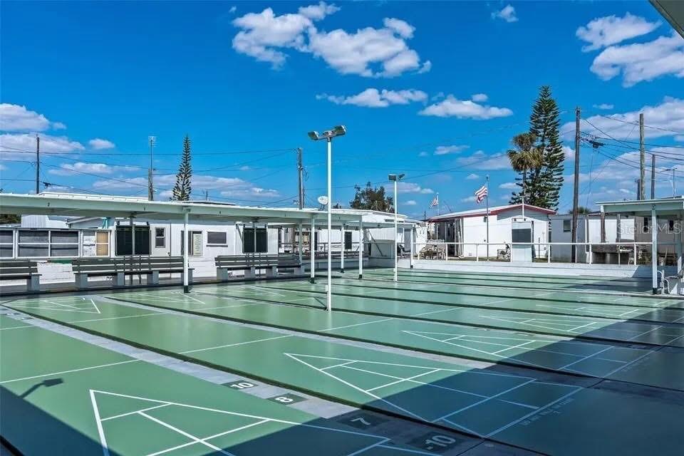 An outdoor shuffleboard court with covered seating areas under a bright blue sky — 138 PENNSYLVANIA STREET, PALMETTO, FL