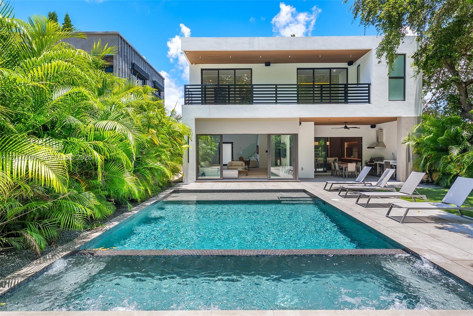 A modern two-story house features a swimming pool, hot tub, and patio with lounge chairs — 260 NW 47th St, Miami FL 33127, MIAMI, FL