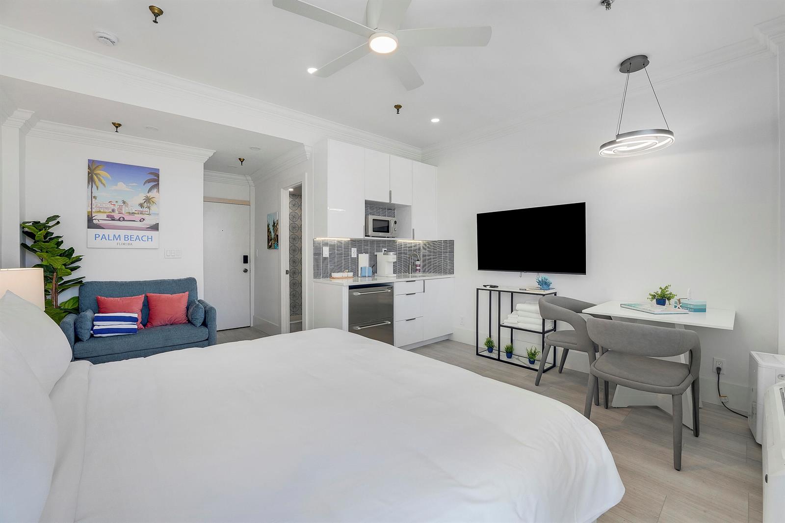 A hotel room features a bed, kitchenette, seating area, and a wall-mounted television — 235 Sunrise Avenue # 2011, Palm Beach FL 33480, PALM BEACH, FL