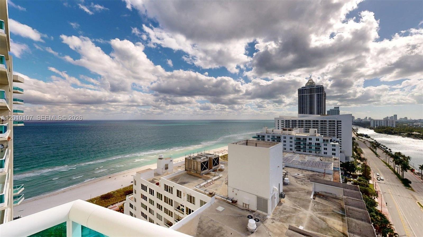 An elevated view shows a beach, ocean, and coastal buildings under a cloudy sky — 5025 Collins Ave # 2206, Miami Beach FL 33140, MIAMI BEACH, FL