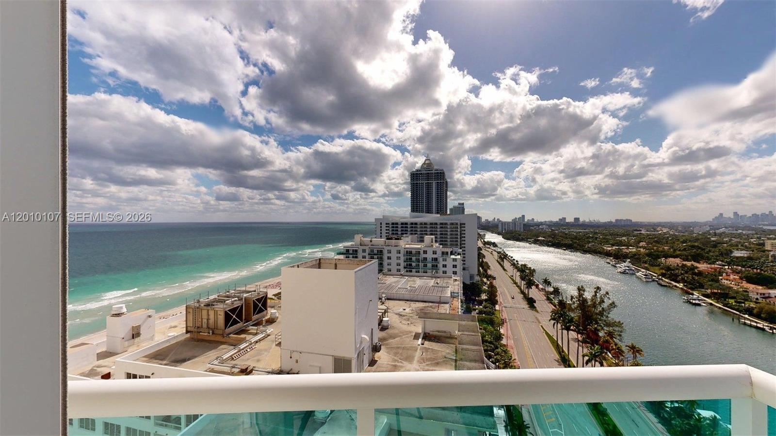 An elevated view from a balcony overlooks the ocean, a coastal road, and a waterway — 5025 Collins Ave # 2206, Miami Beach FL 33140, MIAMI BEACH, FL