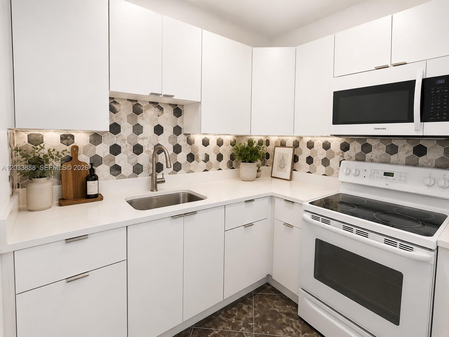 A modern kitchen features white cabinets, a hexagonal tile backsplash, and stainless steel appliances — 20500 NW 28th Ave # A, Miami Gardens FL 33056, MIAMI GARDENS, FL