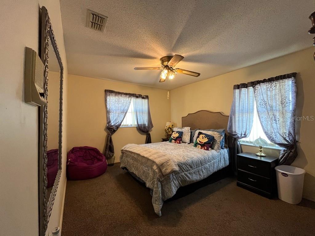A bedroom features a queen bed, a purple beanbag chair, and a large wall mirror — 16920 SW 39TH CIRCLE, OCALA, FL