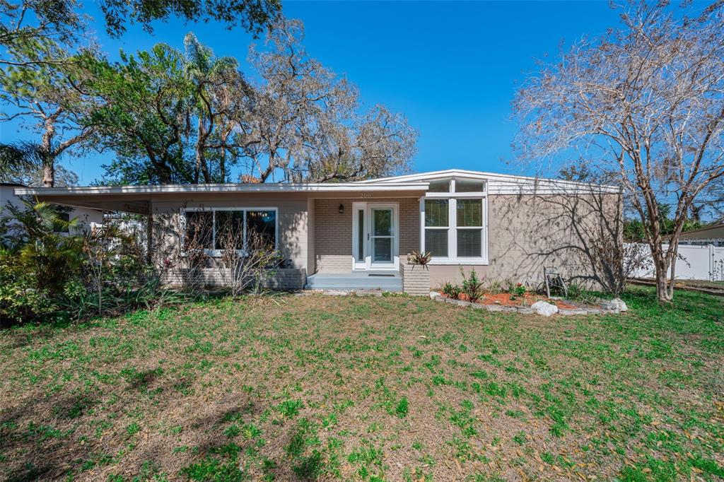 A single-story house with a flat roof, brick facade, and a covered carport — 206 LINDA AVENUE, TEMPLE TERRACE, FL