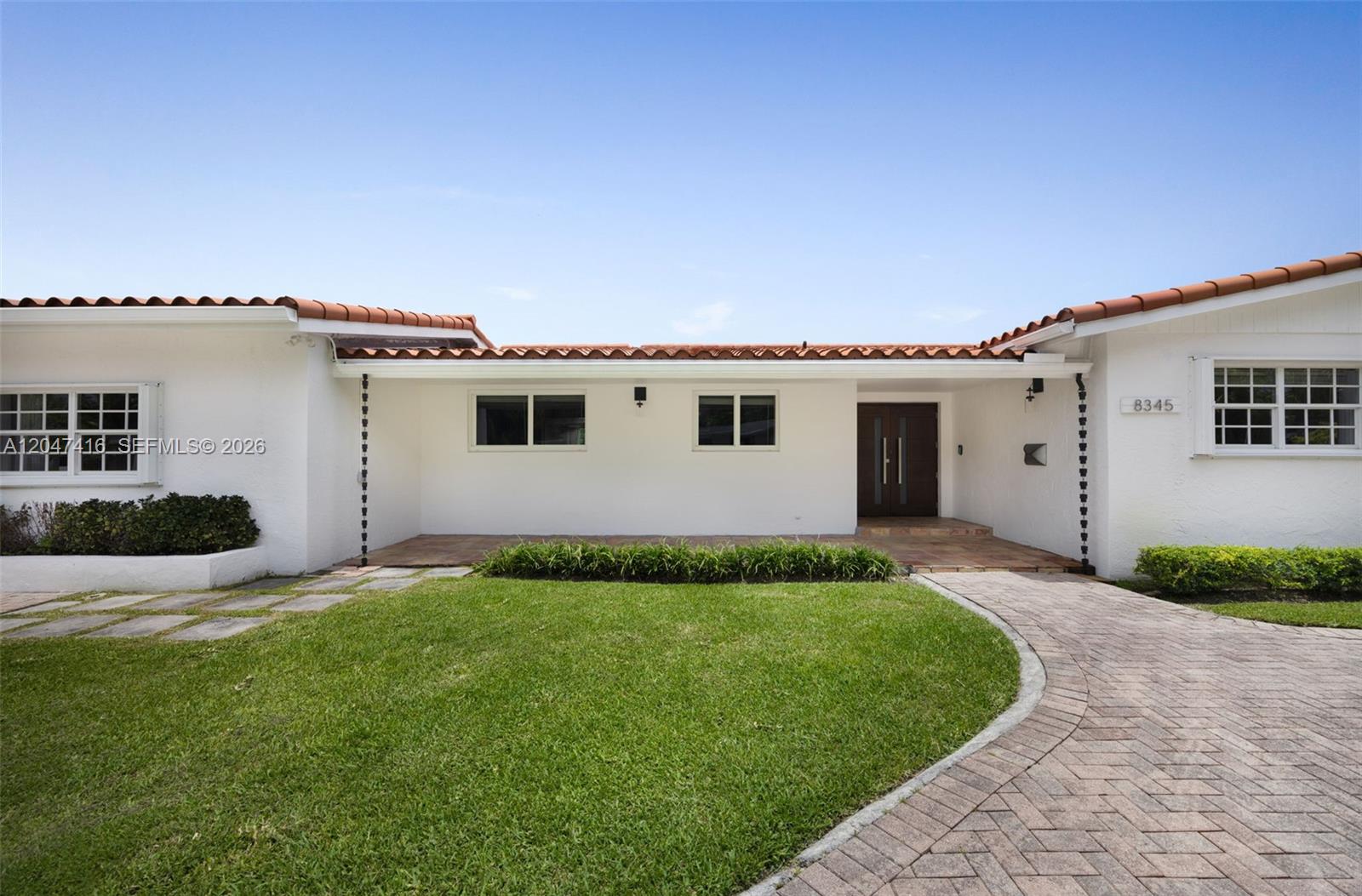 A white single-story house features a red tile roof and a curved brick driveway — 8345 SW 90th St, Miami FL 33156, MIAMI, FL