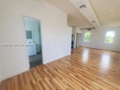An interior view shows a room with wood-look flooring and a doorway to a bathroom — 101 SE 2nd St # 2, Dania Beach FL 33004, DANIA BEACH, FL