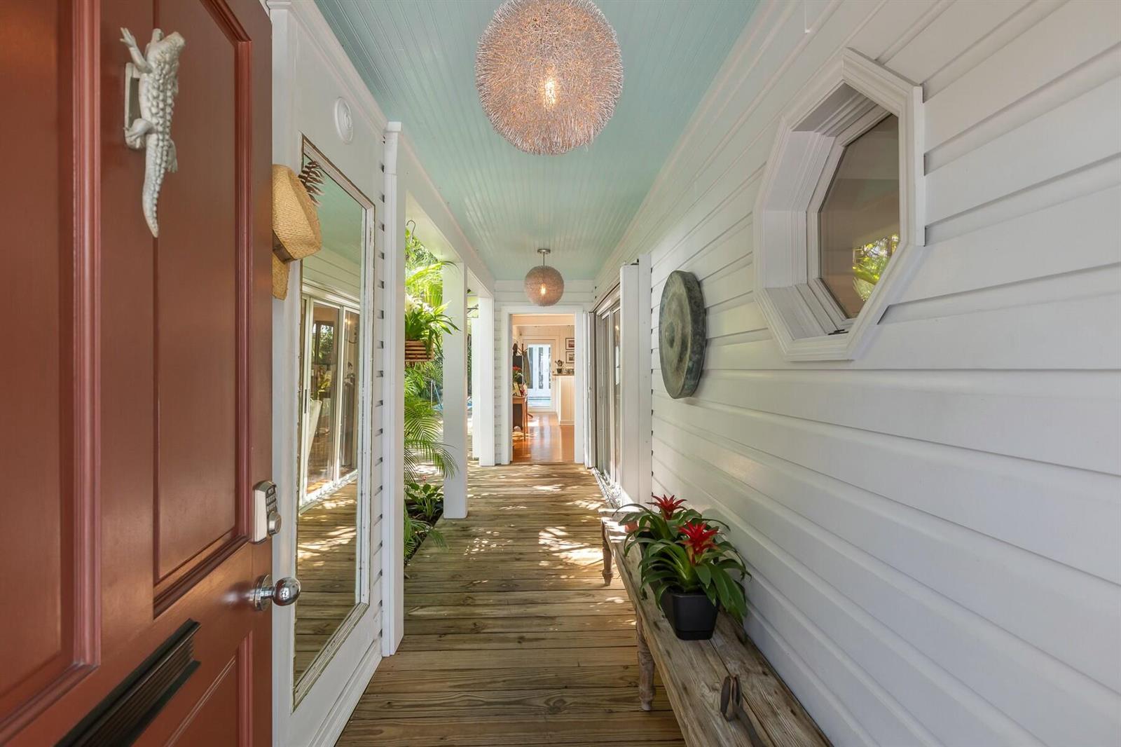 A covered wooden porch features a light blue ceiling, hanging light fixtures, and a bench — 508 Grinnell Street, Key West FL 33040, KEY WEST, FL