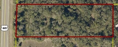 An aerial view shows a rectangular, wooded plot of land adjacent to a highway — 0 NE 308th Street, Okeechobee FL 34972, OKEECHOBEE, FL