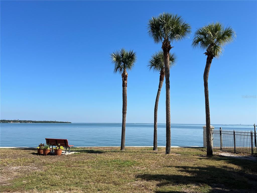 An aerial view shows waterfront homes next to a long bridge over the bay — 7550 SUNSHINE SKYWAY LANE S UNIT P11, ST PETERSBURG, FL