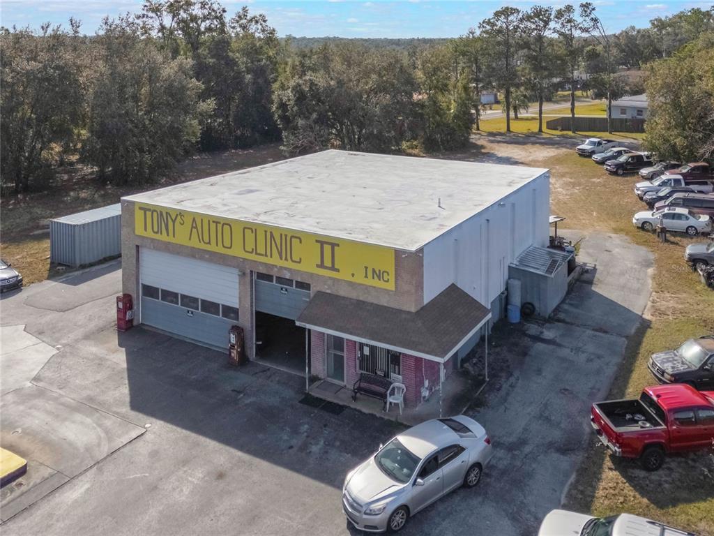An aerial view of a commercial auto repair shop with a large yellow sign — 3190 S FLORIDA AVENUE, INVERNESS, FL