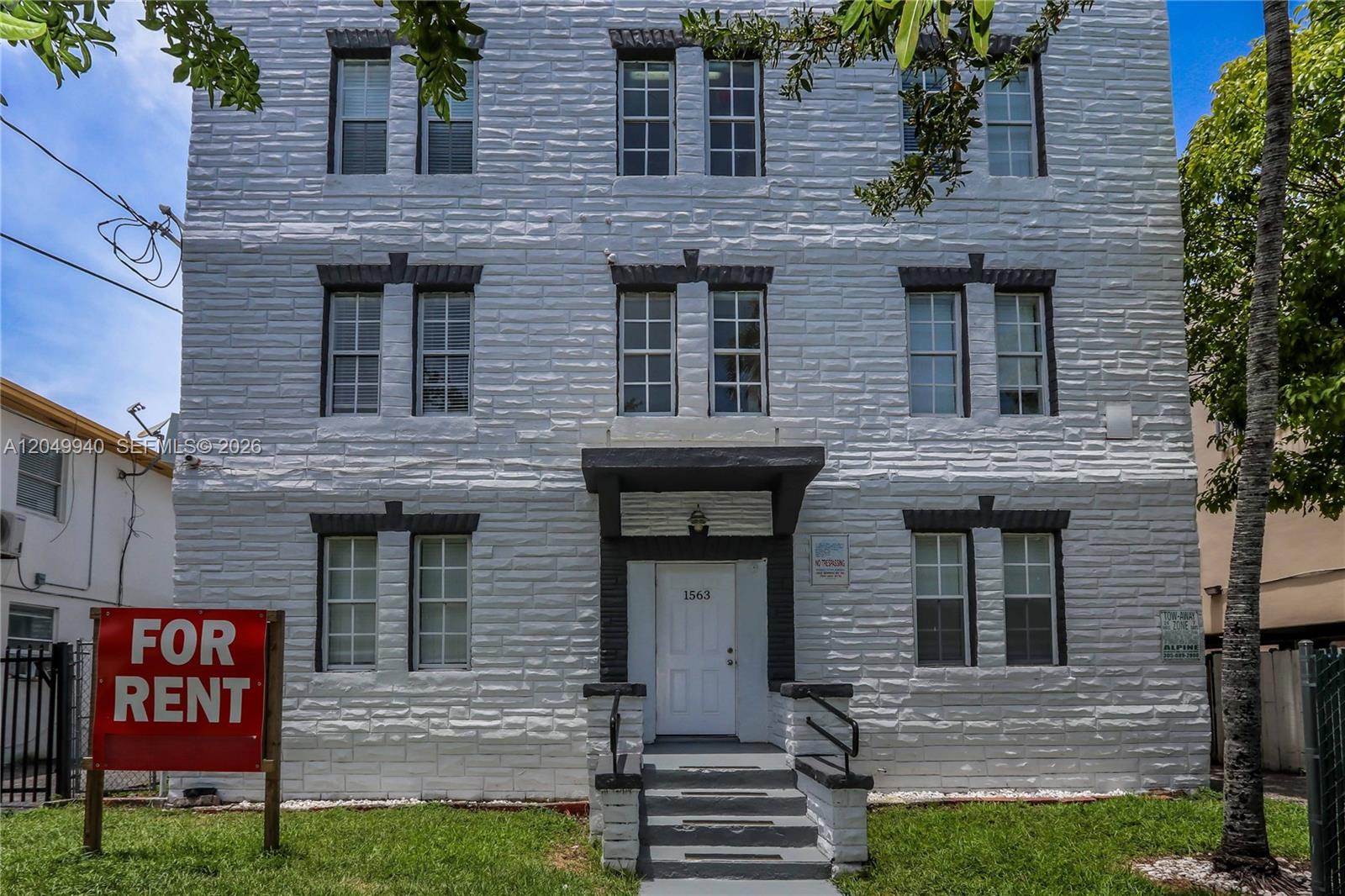 A three-story white brick apartment building features a central entrance with a small porch — 1563 SW 2nd St, Miami FL 33135, MIAMI, FL