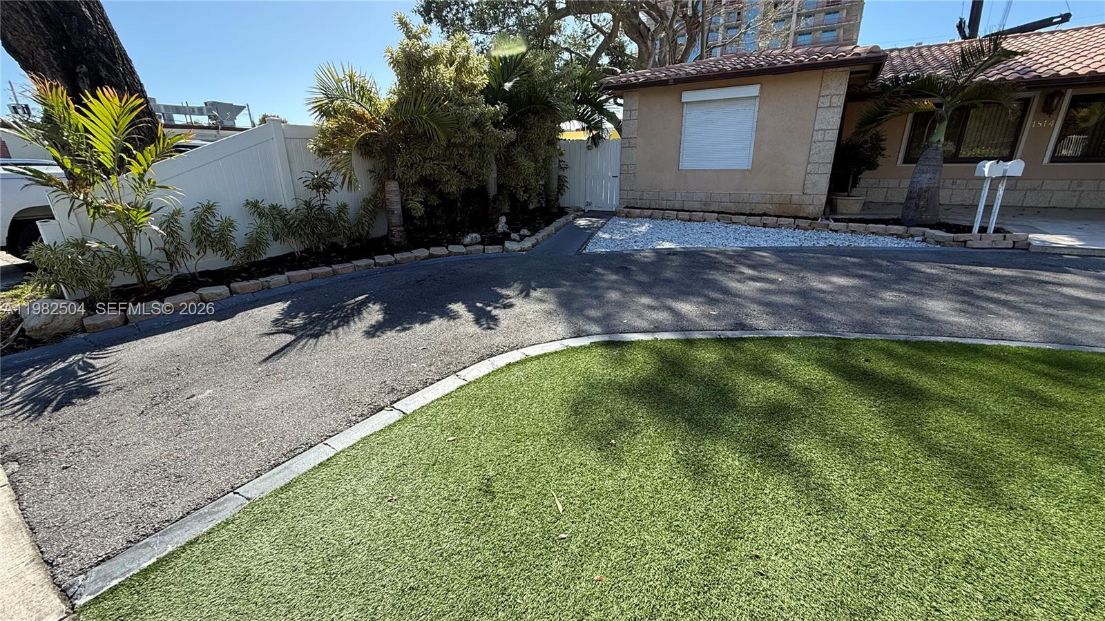 A paved driveway leads to a house with a lawn and landscaping — 1814 Thomas St Rear, Hollywood FL 33020, HOLLYWOOD, FL