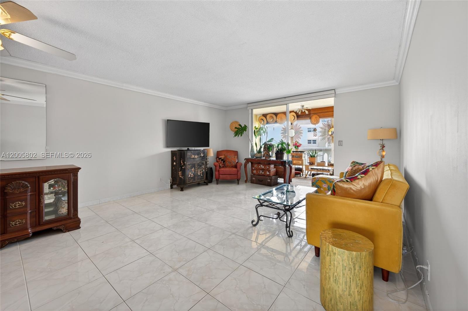 A living room features white tile floors, a yellow sofa, and a glass coffee table — 610 NE 12th Ave # 602, Hallandale Beach FL 33009, HALLANDALE BEACH, FL
