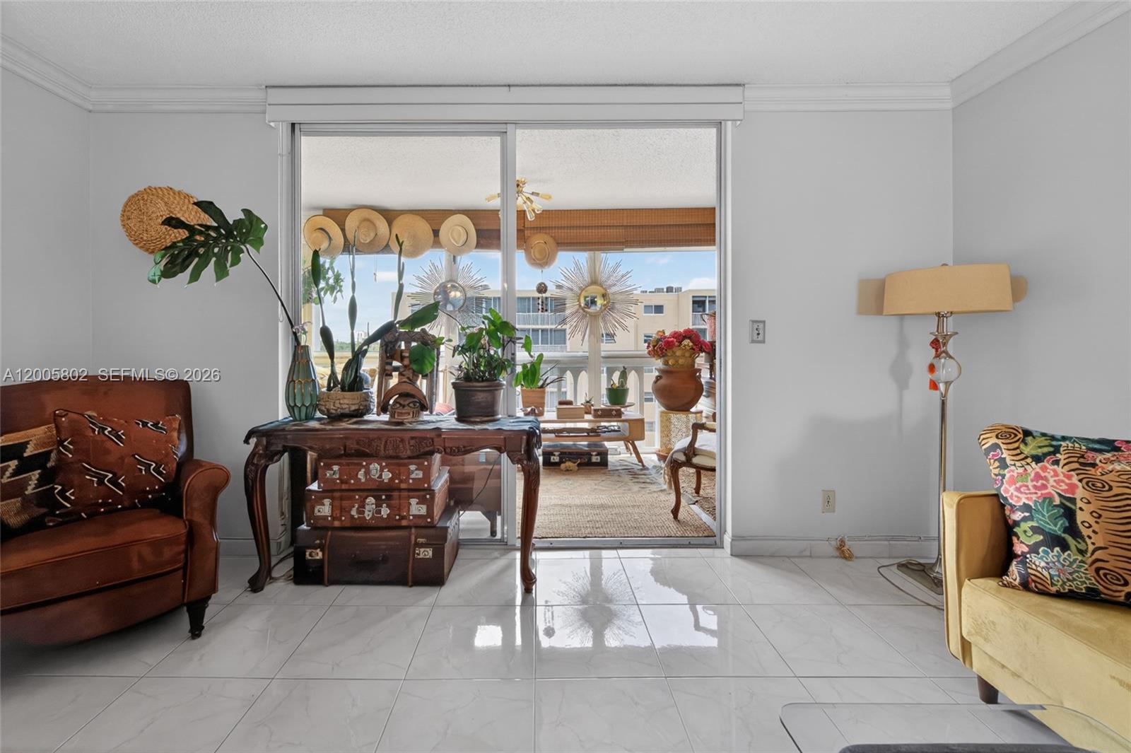 A living room with white tile floors opens to a balcony through a sliding glass door — 610 NE 12th Ave # 602, Hallandale Beach FL 33009, HALLANDALE BEACH, FL