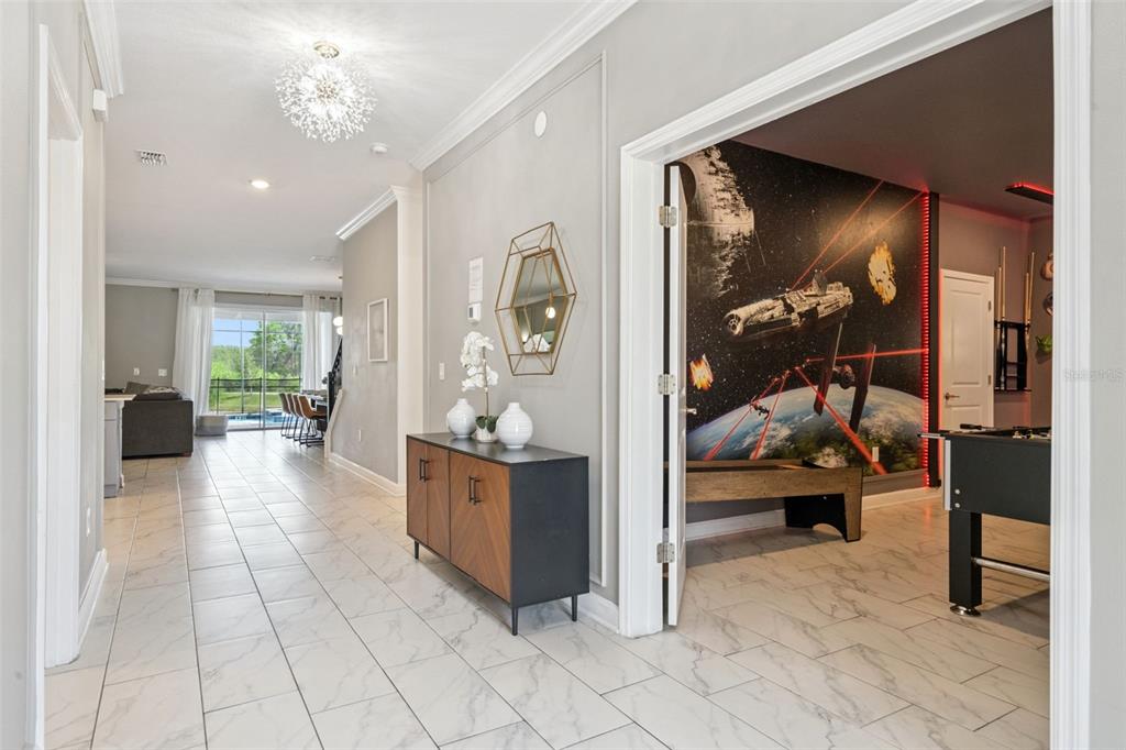A hallway with tile flooring leads to a living area and a Star Wars-themed room — 2876 SIMILE STREET, KISSIMMEE, FL