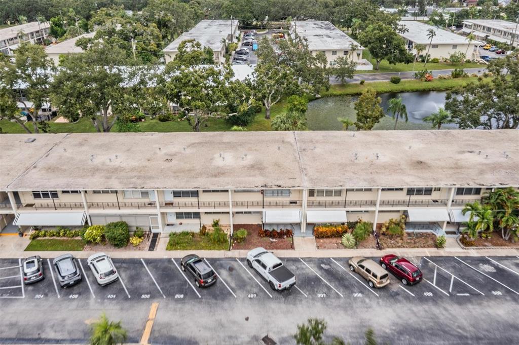 An aerial view shows a multi-story apartment building with a parking lot in front — 5665 40TH AVENUE N UNIT 407, KENNETH CITY, FL