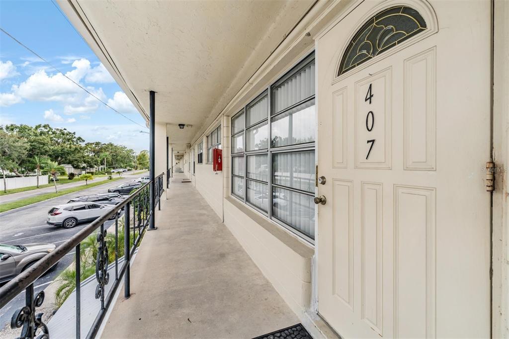 An exterior walkway leads to the front door of a unit numbered 407 — 5665 40TH AVENUE N UNIT 407, KENNETH CITY, FL