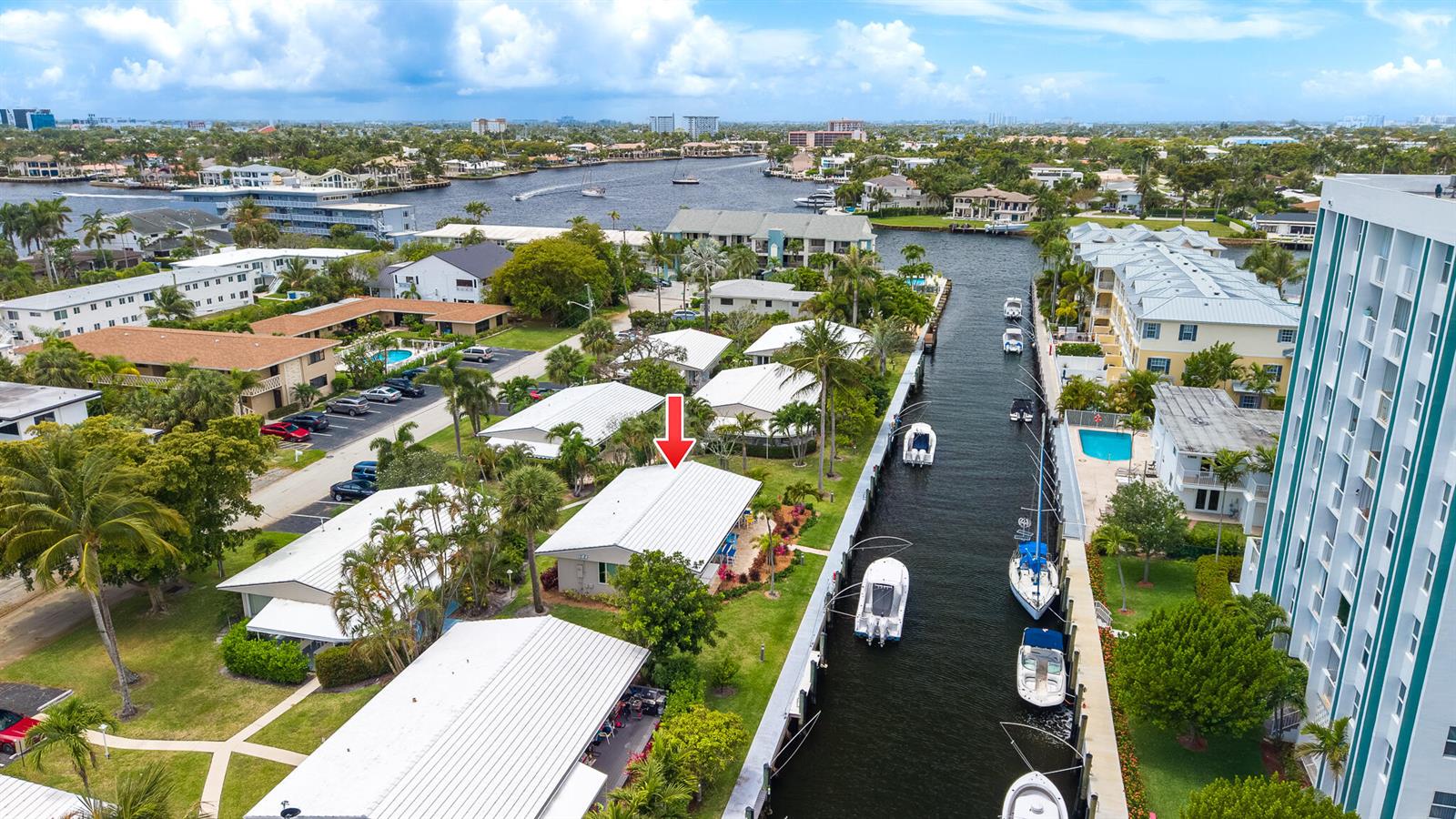 An aerial view shows a waterfront house with a metal roof beside a boat canal — 3211 SE 11th Street # 3e, Pompano Beach FL 33062, POMPANO BEACH, FL