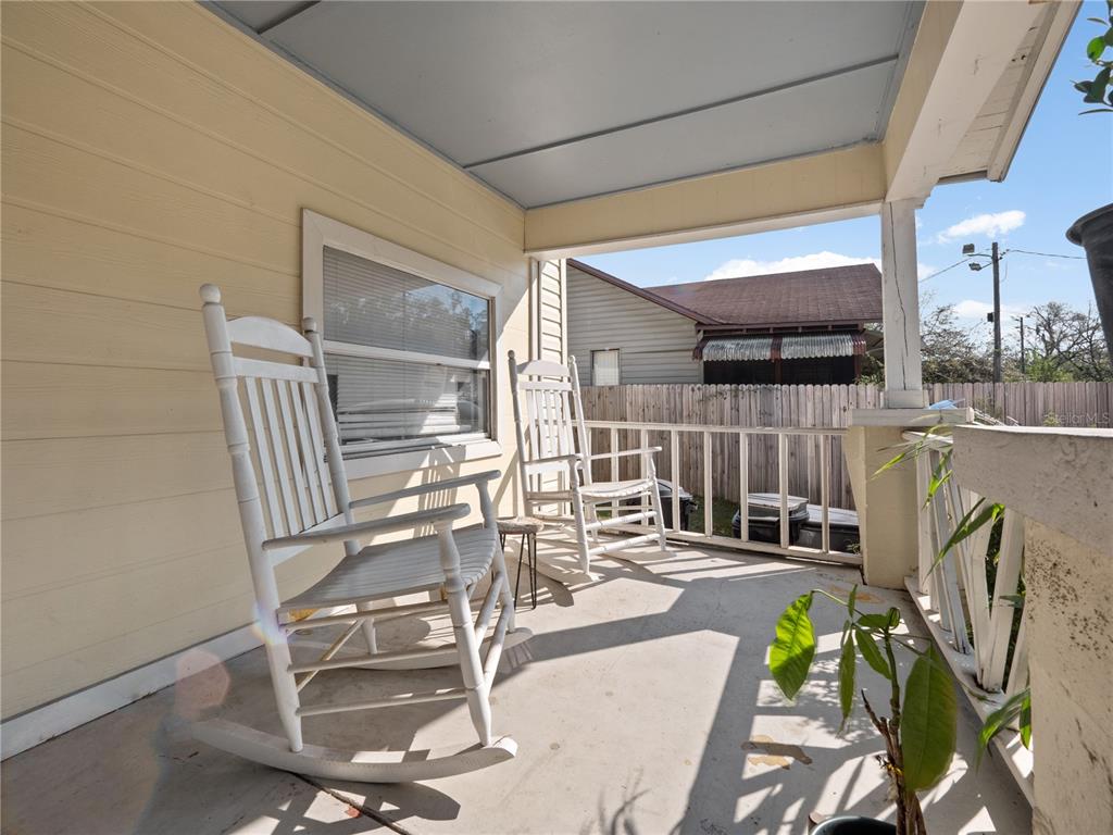 A covered front porch features two white rocking chairs and a small side table — 1208 W 10TH STREET, SANFORD, FL