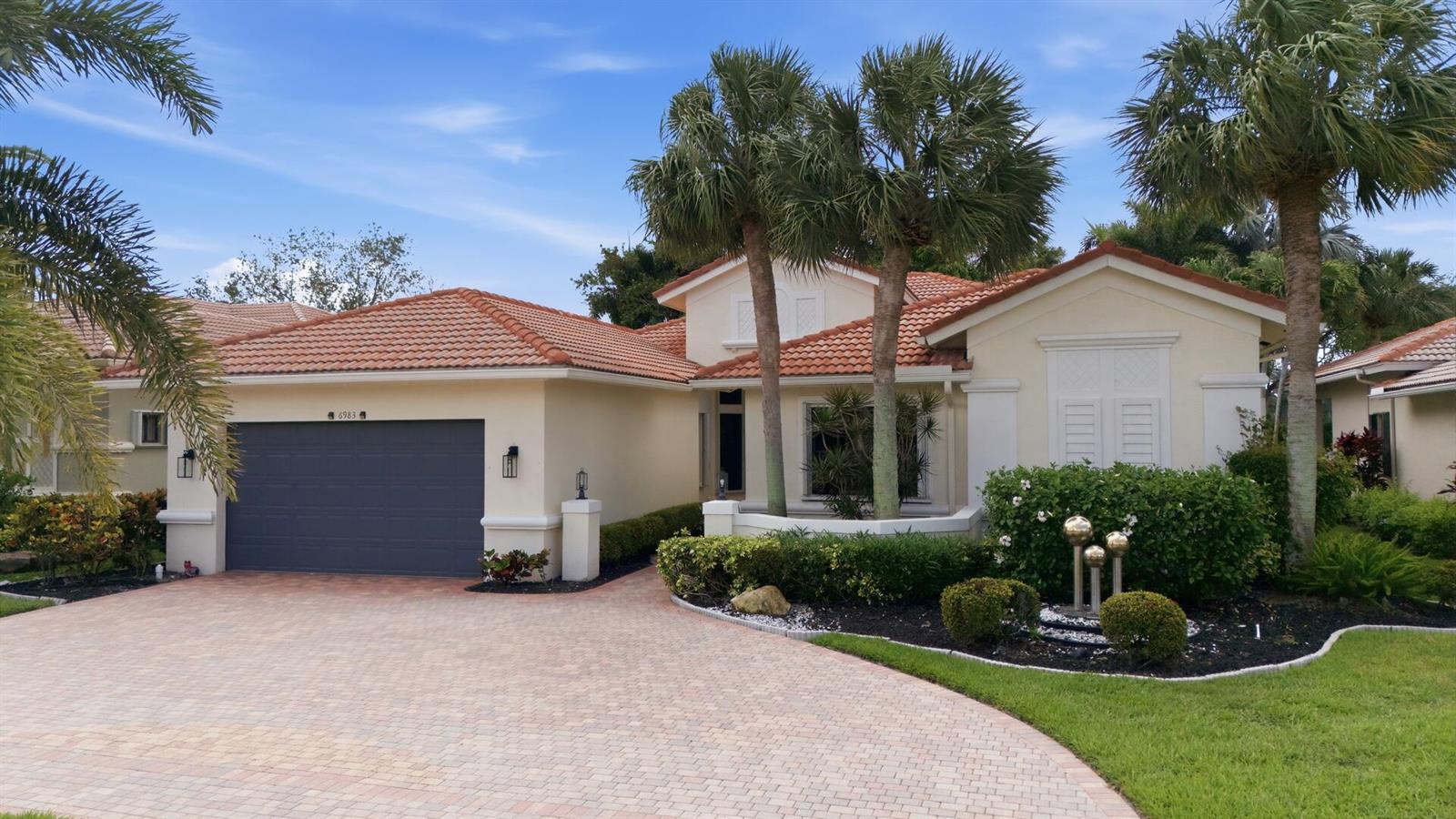 A single-story house with a terracotta tile roof, gray garage door, and paved driveway — 6983 Antinori Lane, Boynton Beach FL 33437, BOYNTON BEACH, FL