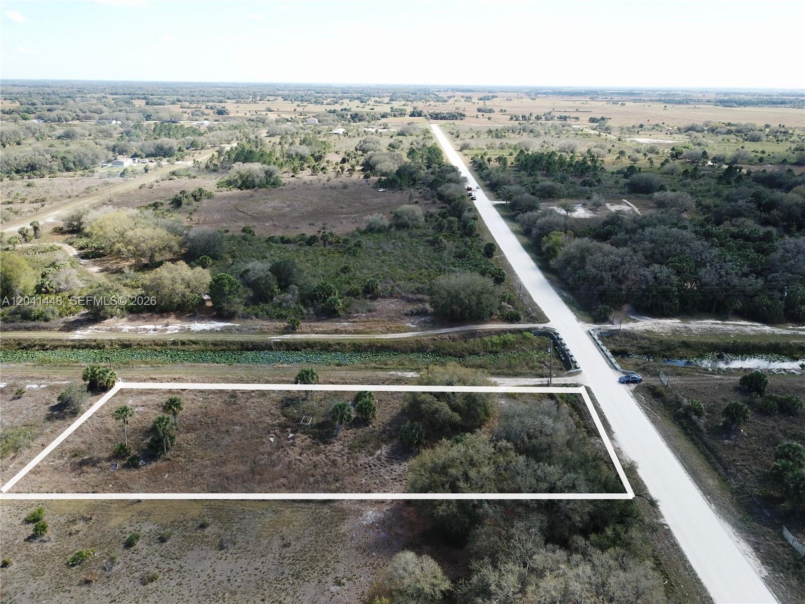 An aerial view shows a rectangular plot of land bordered by a dirt road — 15129 NW 288th St, Okeechobee FL 34972, OKEECHOBEE, FL