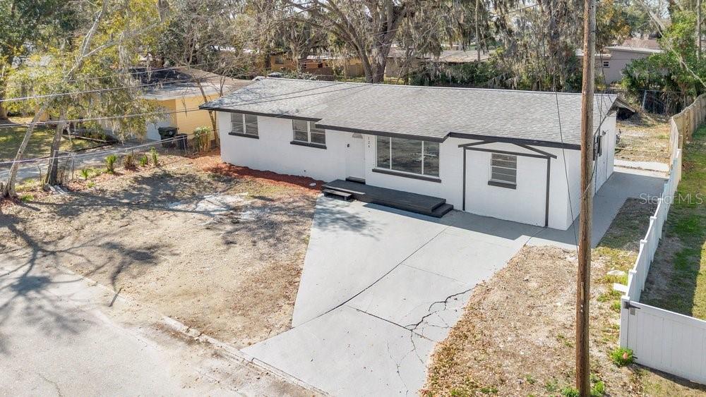 An aerial view of a single-story white house with a gray roof and concrete driveway — 124 BAYWOOD DRIVE, DAYTONA BEACH, FL