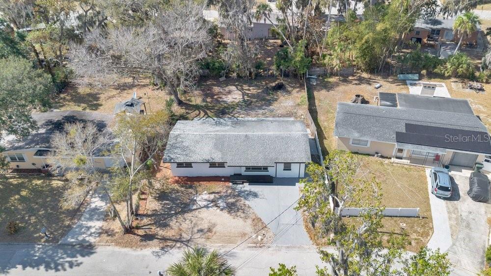 An aerial view of a single-story house with a gray roof and a paved driveway — 124 BAYWOOD DRIVE, DAYTONA BEACH, FL