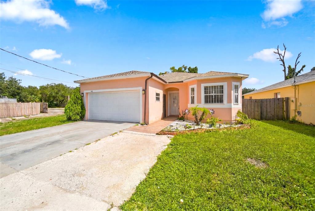A peach-colored single-story house features a white garage door and a front-facing bay window — 4404 AMERICA STREET, ORLANDO, FL