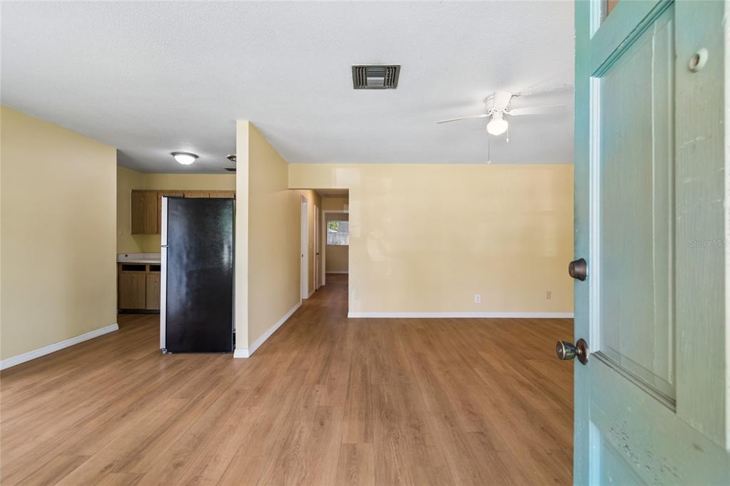 A view from an open doorway into a living room with light-colored walls and flooring — 6706 S MASCOTTE STREET, TAMPA, FL
