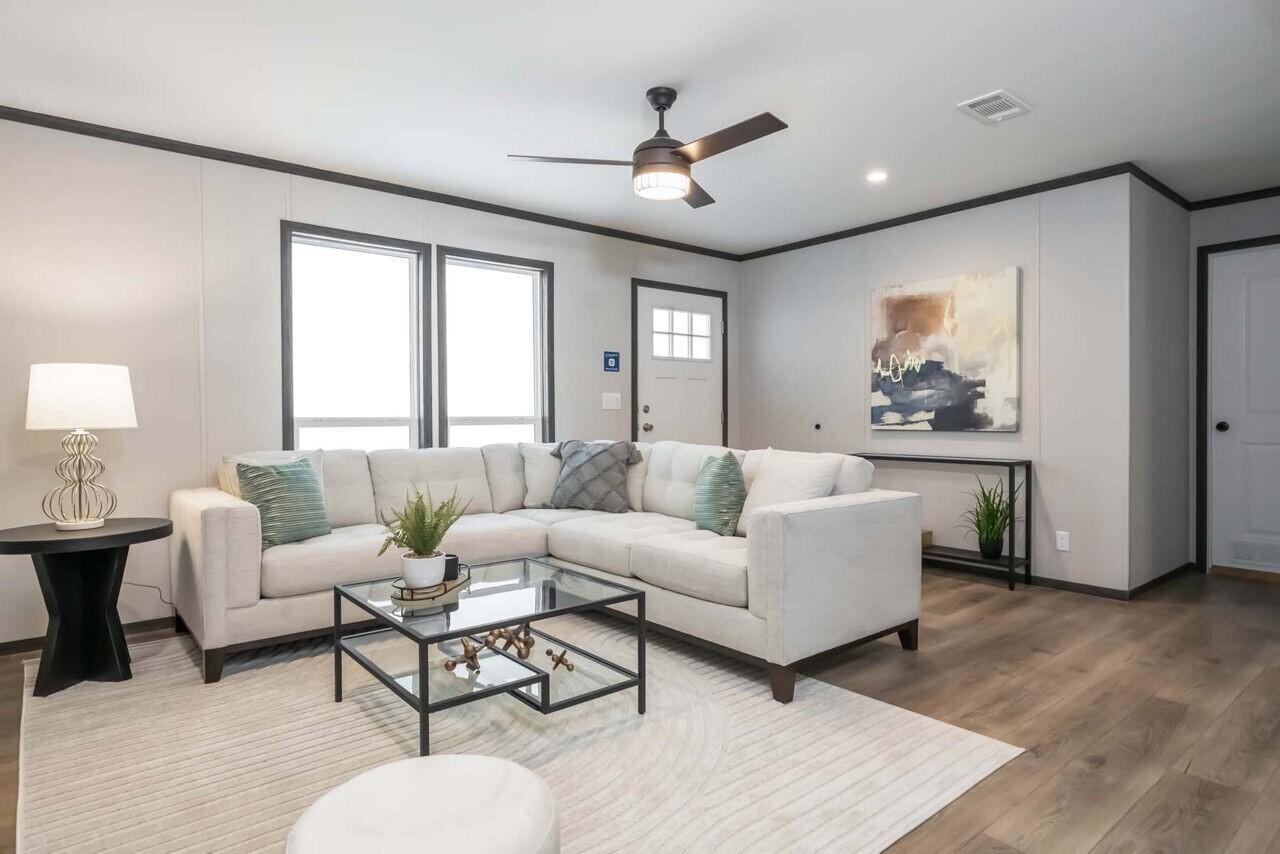 A living room features a white sectional sofa, glass coffee table, and light wood flooring — 19520 NW 260th Street, Okeechobee FL 34972, OKEECHOBEE, FL
