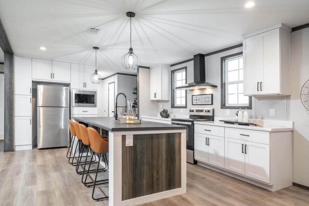 A modern kitchen features white cabinetry, a dark wood-paneled island, and stainless steel appliances — 19520 NW 260th Street, Okeechobee FL 34972, OKEECHOBEE, FL