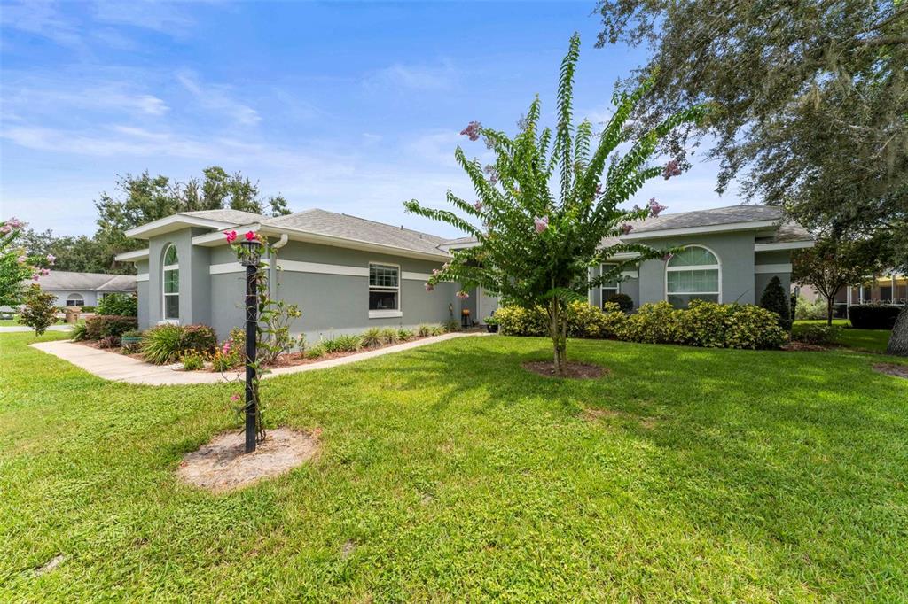 A single-story gray house with a lawn, a small tree, and a lamp post — 11218 FOUNTAIN LAKE BOULEVARD, LEESBURG, FL