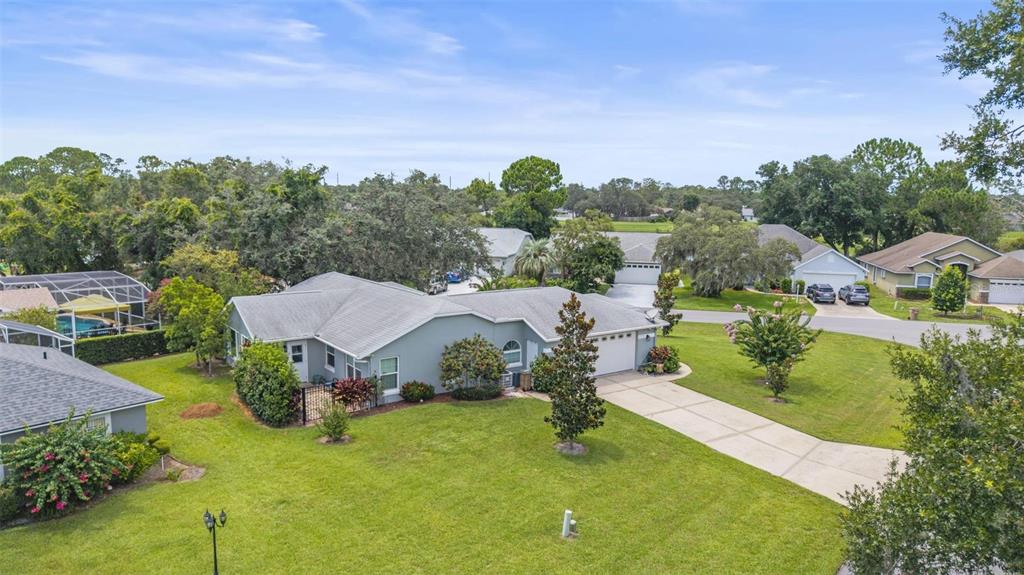 An aerial view of a single-story suburban house with a gray roof and driveway — 11218 FOUNTAIN LAKE BOULEVARD, LEESBURG, FL