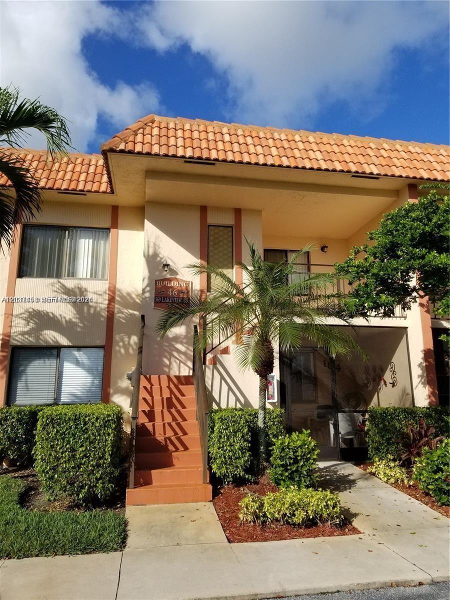 A two-story residential building features a tiled roof, tan stucco walls, and an exterior staircase — 369 Lakeview Dr # 204, Weston FL 33326, WESTON, FL