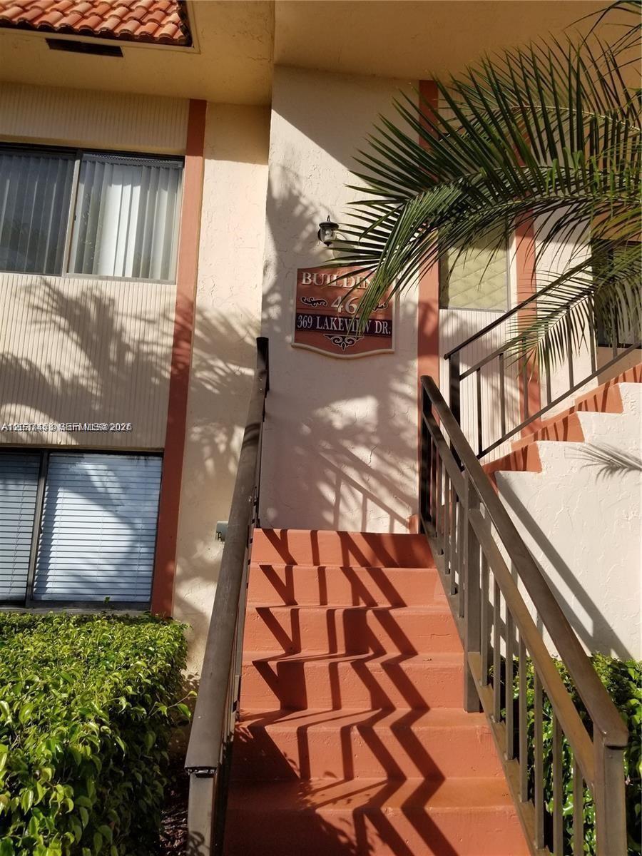 An exterior view shows a set of orange stairs leading to a building entrance — 369 Lakeview Dr # 204, Weston FL 33326, WESTON, FL