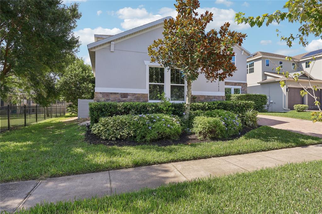 A single-story house with a stone-accented facade, a front garden, and a paved driveway — 14612 GLADE HILL PARK WAY, WINTER GARDEN, FL