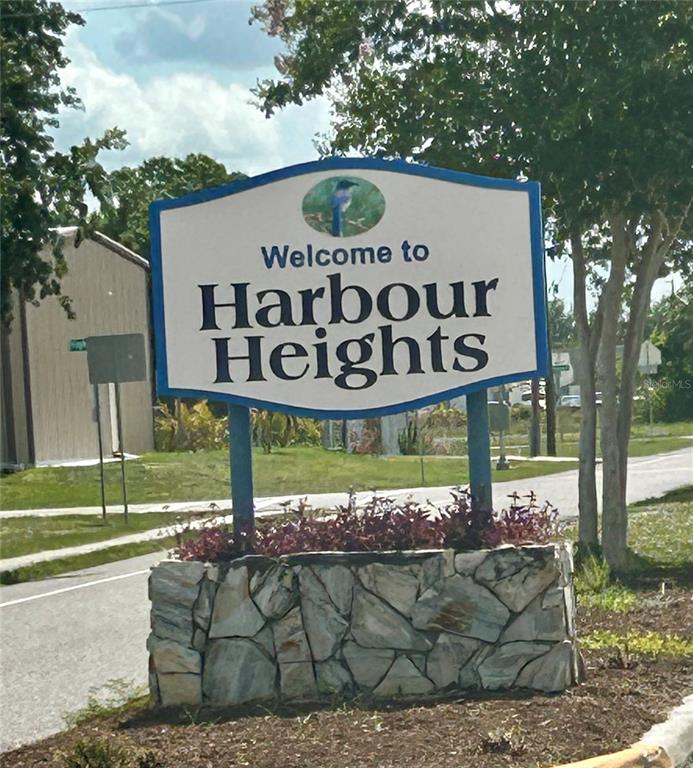 A sign reading Welcome to Harbour Heights stands above a stone planter near a road — 3273 SANTA BARBARA DRIVE, PUNTA GORDA, FL