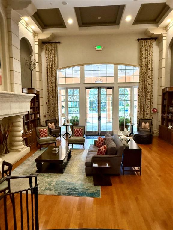 A spacious living room features high ceilings, a fireplace, large windows, and hardwood floors — 501 MIRASOL CIRCLE UNIT 301, CELEBRATION, FL