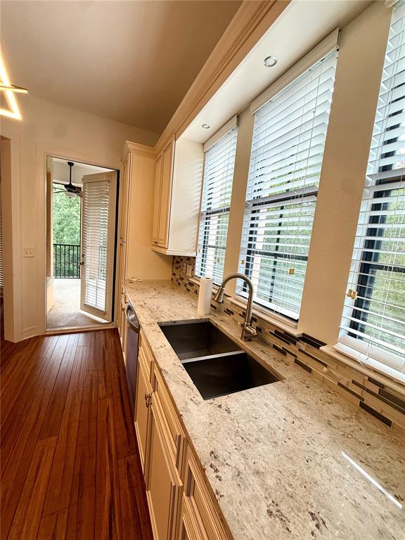 A kitchen features granite countertops, a double-basin sink, light wood cabinets, and a balcony doorway — 501 MIRASOL CIRCLE UNIT 301, CELEBRATION, FL