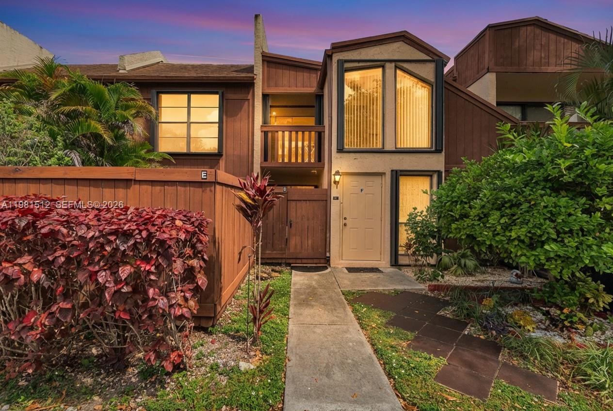 A two-story townhouse exterior features brown wood siding, a tan front door, and a walkway — 6411 SW 116th Ct, Miami FL 33173, MIAMI, FL