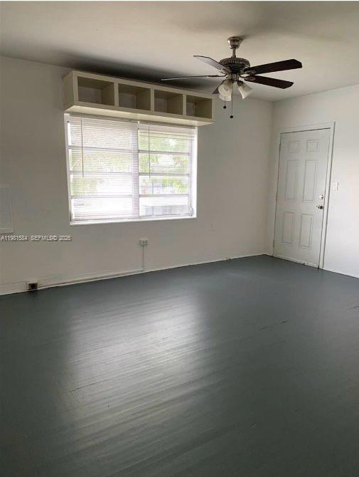 An empty room features gray painted floors, a ceiling fan, and a white storage shelf — 424 NE 82nd St # 4C, Miami FL 33138, MIAMI, FL