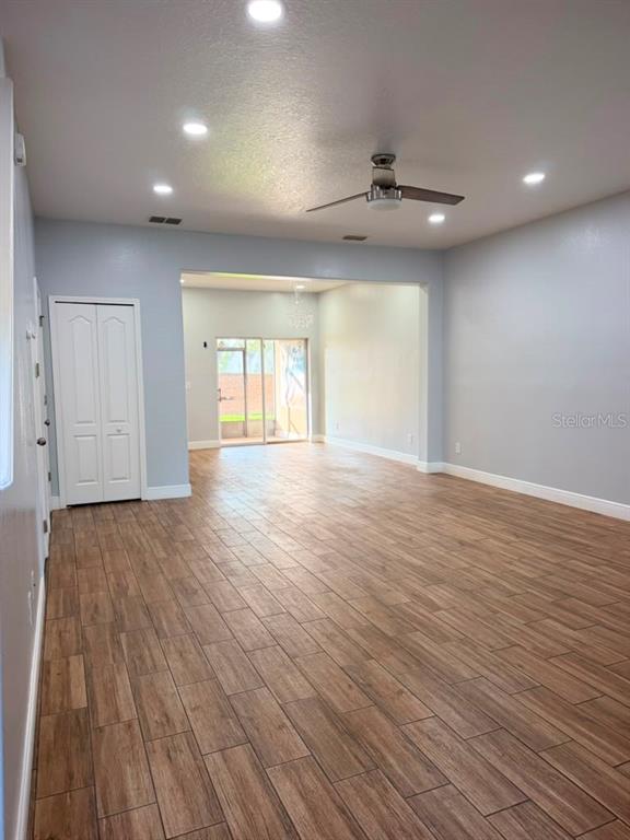 An empty room features light gray walls, wood-look tile flooring, recessed lighting, and a ceiling fan — 2962 RODRICK CIRCLE, ORLANDO, FL