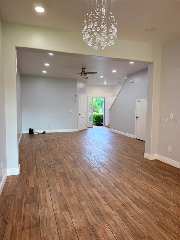 An open-concept living area features wood-look tile flooring, recessed lighting, and a modern crystal chandelier — 2962 RODRICK CIRCLE, ORLANDO, FL