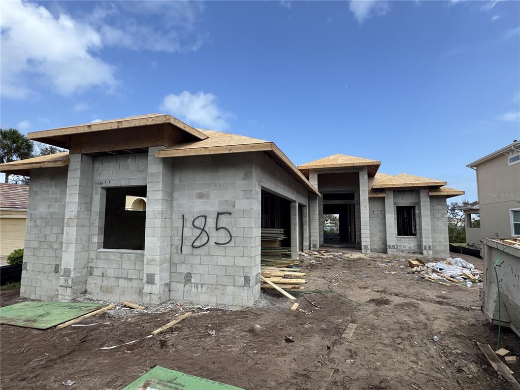 A single-story concrete block house under construction with a wooden roof frame — 185 S RIVERWALK DRIVE, PALM COAST, FL