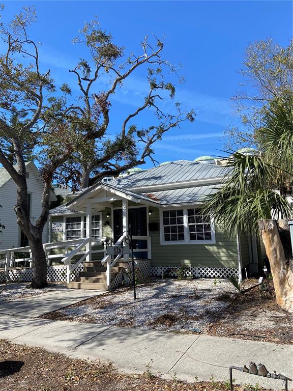 A light green house with a metal roof and a wooden wheelchair ramp — 1267 2ND STREET, SARASOTA, FL