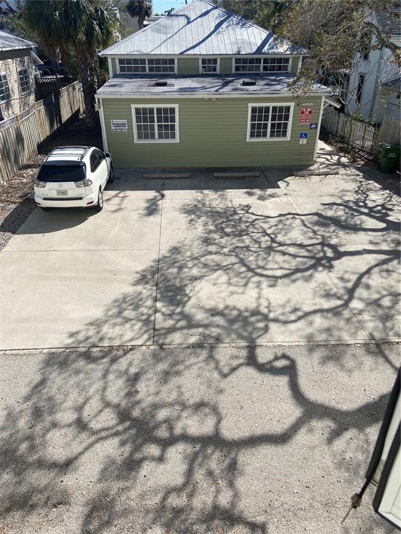 An exterior view of a light green building with a metal roof and a parking lot — 1267 2ND STREET, SARASOTA, FL
